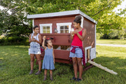 Three girls holding chickens in front of Large OverEZ Chicken Coop
